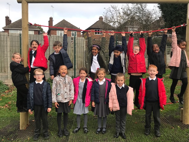 Primary school pupils enjoying playground equipment