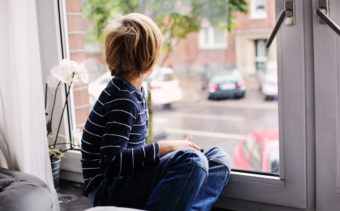 Young boy looking out of window