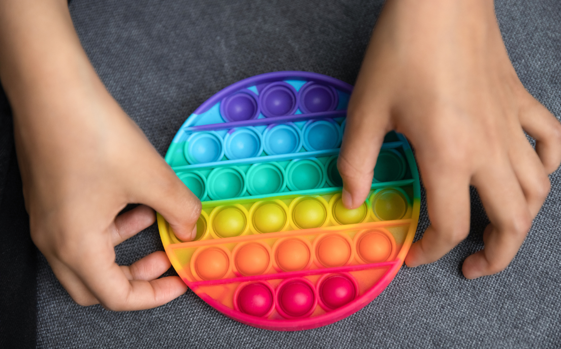 Child playing with rainbow pop-it