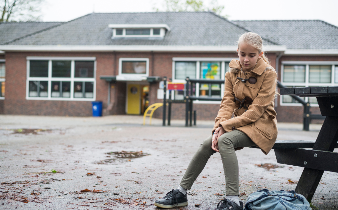 Girl sitting alone in playground