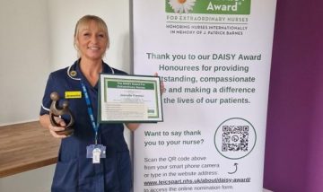 Jeanette Preston holding DAISY Award certificate and “Healer’s Touch” sculpture.