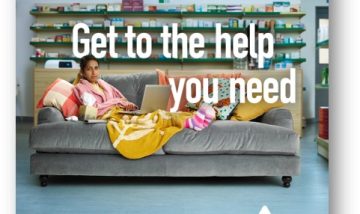 A woman with a cold laying on a sofa in an NHS pharmacy. She is using her laptop to contact NHS 111.