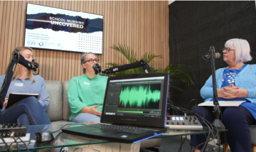Image showing three people in a studio recording a podcast, includes microphones and a laptop