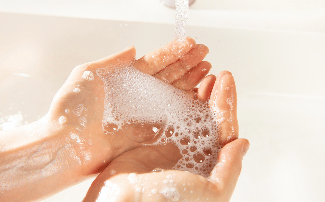 hands holding soap over a basin