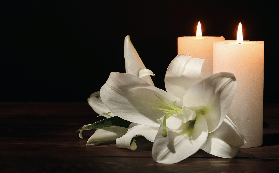 candles and white lilies on black background
