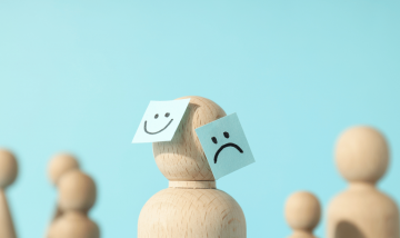 wooden peg with sticky labels stuck to it. happy face/sad face