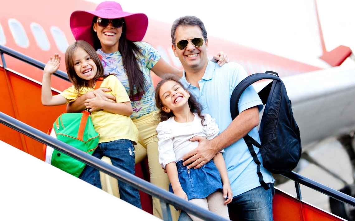 Family smiling boarding an airplane with bags