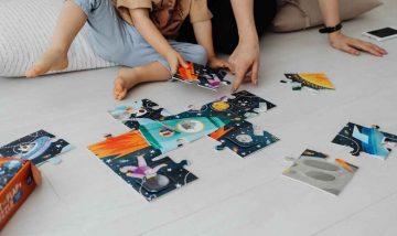 Parent and Child solving a puzzle on the floor.