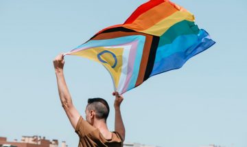 Man holding LGBTQIA+ flag