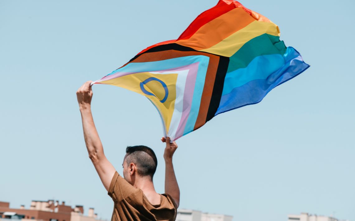 Man holding LGBTQIA+ flag
