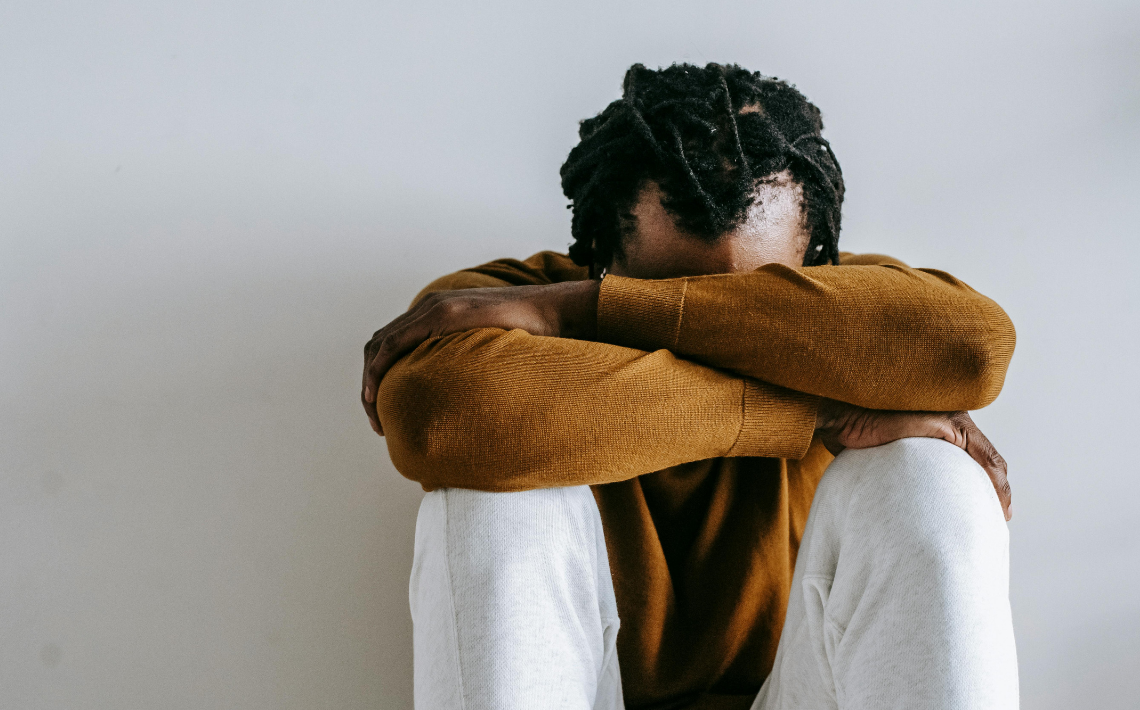 Man Sat Crossed Armed against white background