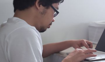 man typing on computer - view from side