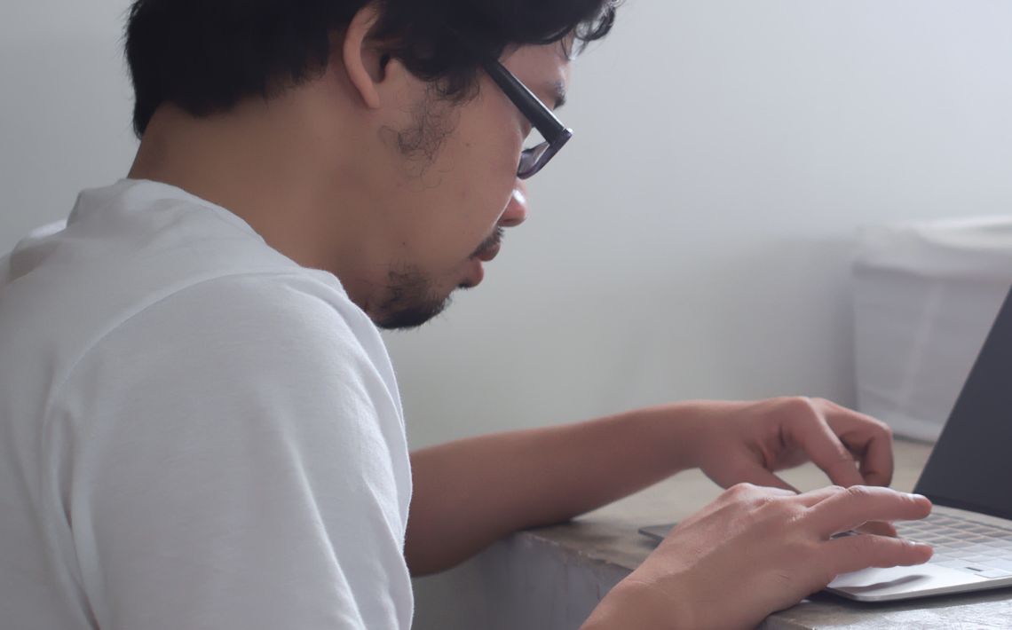 man typing on computer - view from side